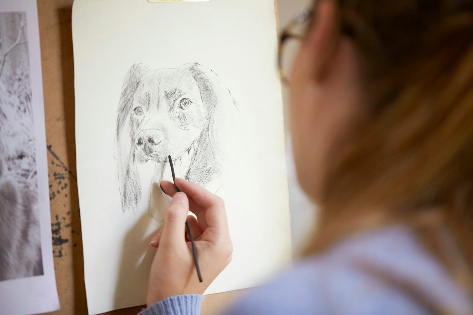 Close Up Of Female Teenage Artist Sitting At Easel Drawing Picture Of Dog In Charcoal