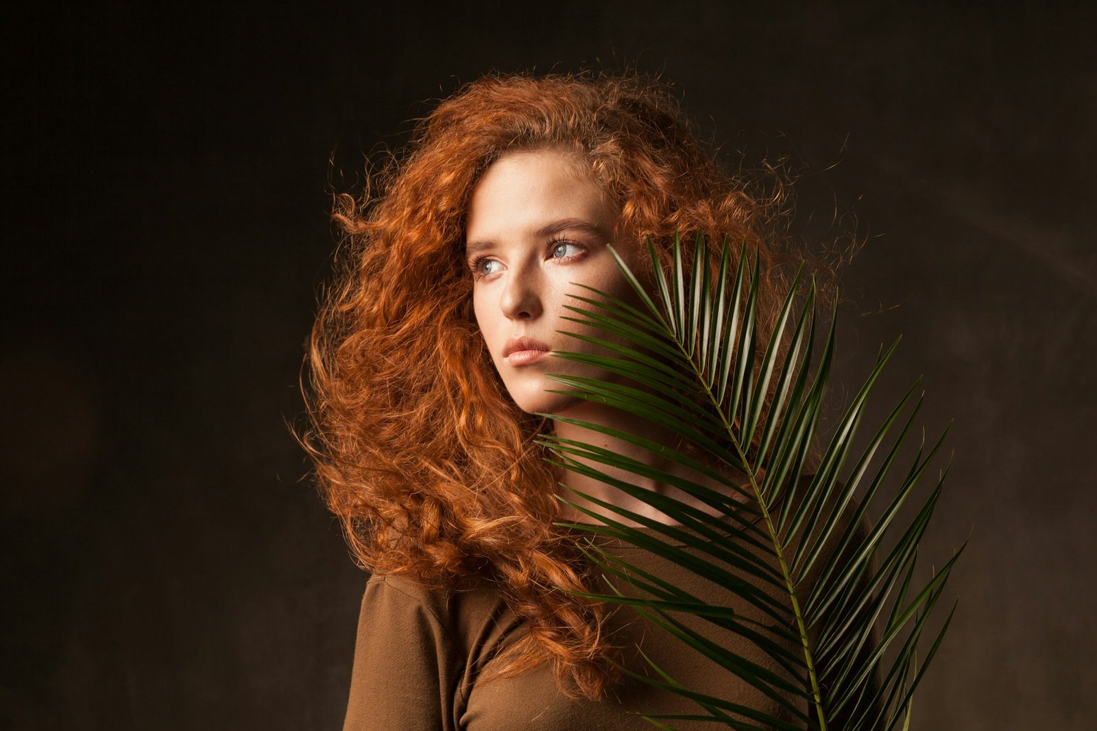 How to Choose the Perfect Ginger Wig With a Promo Code Energizer beautiful young curly ginger hair woman with green tropical plant palm branch