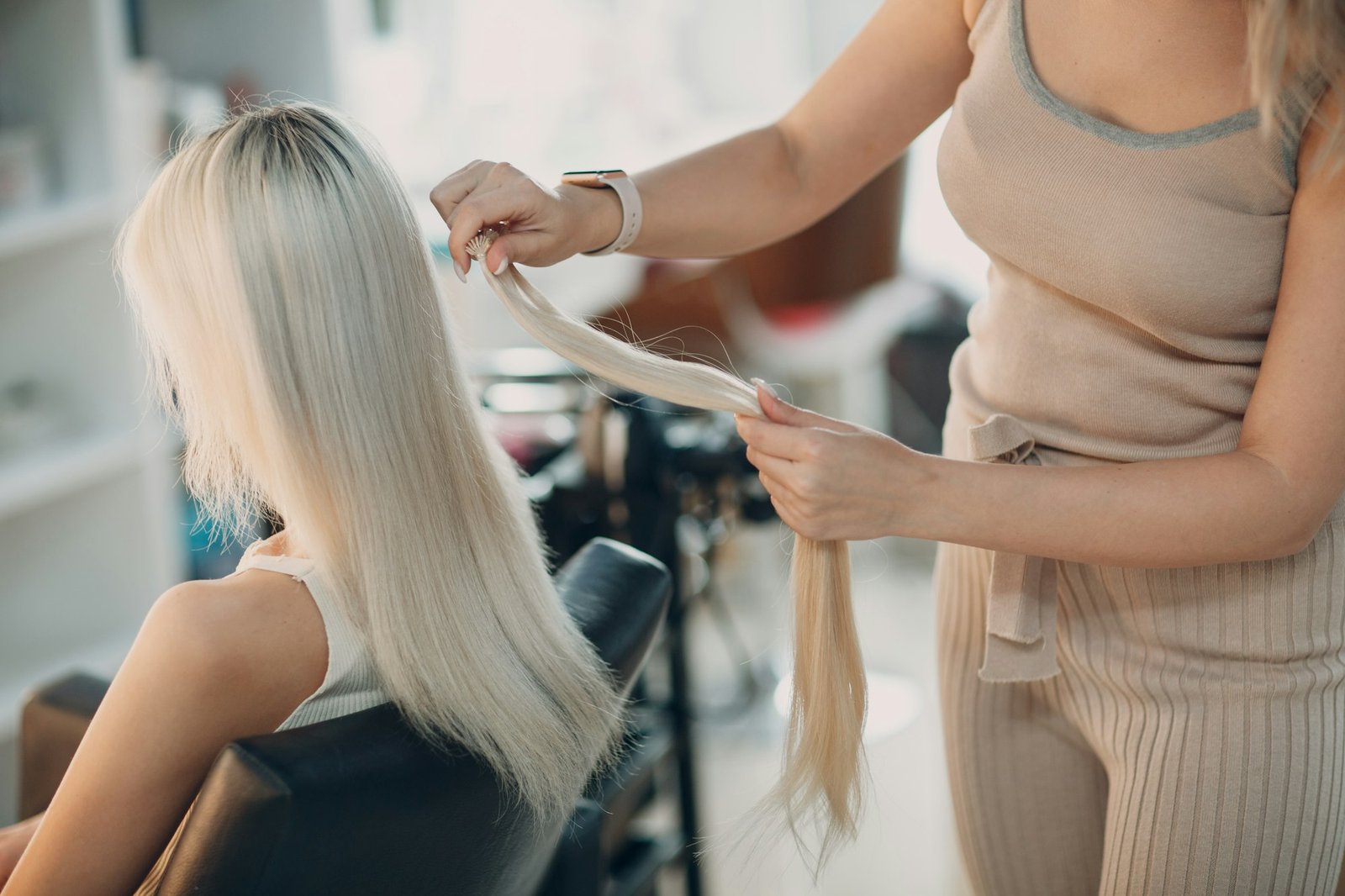 6d hair extensions 6d hair extensions pros and cons 6d hair extensions near me 6d hair extensions reviews 6d hair extensions before and after what are 6d hair extensions how to make 6d hair extensions Hairdresser female making hair extensions to young woman with blonde hair in beauty salon.