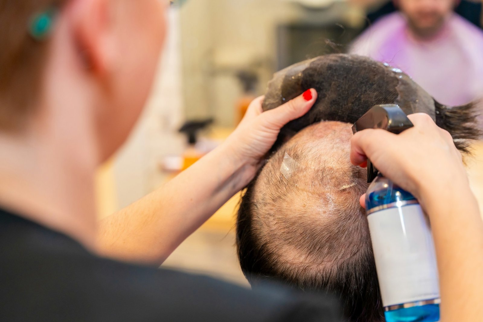 Wig Glue Mistakes to Avoid for a Flawless Finish Hairstylist removing carefully a capillary prosthesis from client head