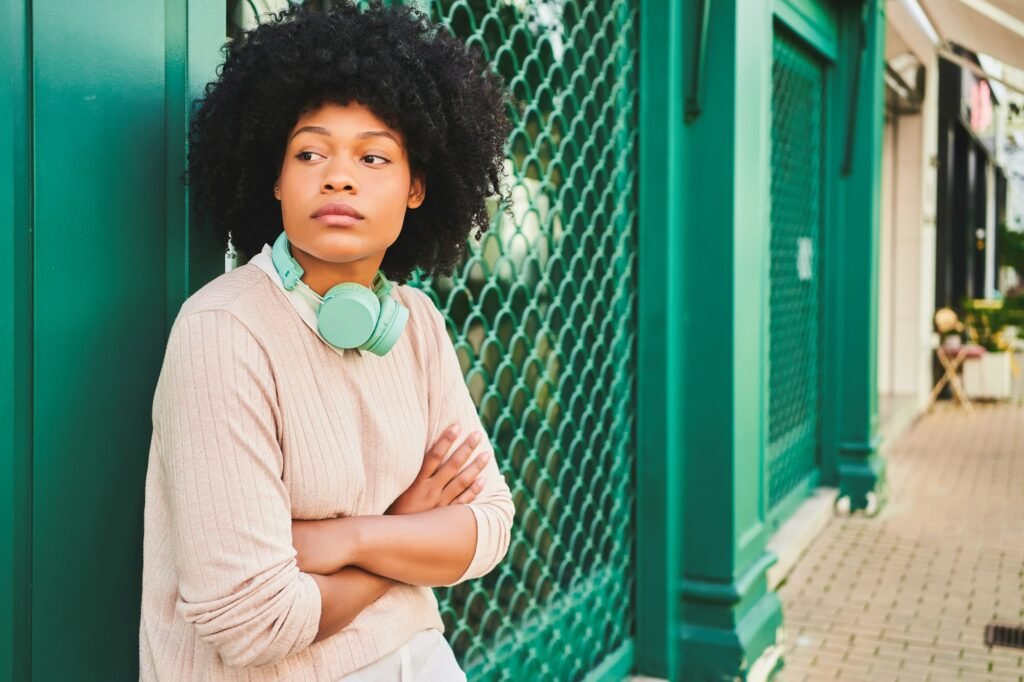 How to Choose the Perfect Afro Wig + Exclusive Promo Code Latina woman with afro hair with her arms crossed. Horizontal portrait of African American woman.