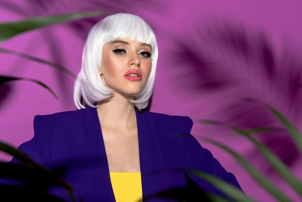 How a White Wig Can Elevate Your Everyday Style Promo Code Serious young woman in white wig looking at camera on purple background